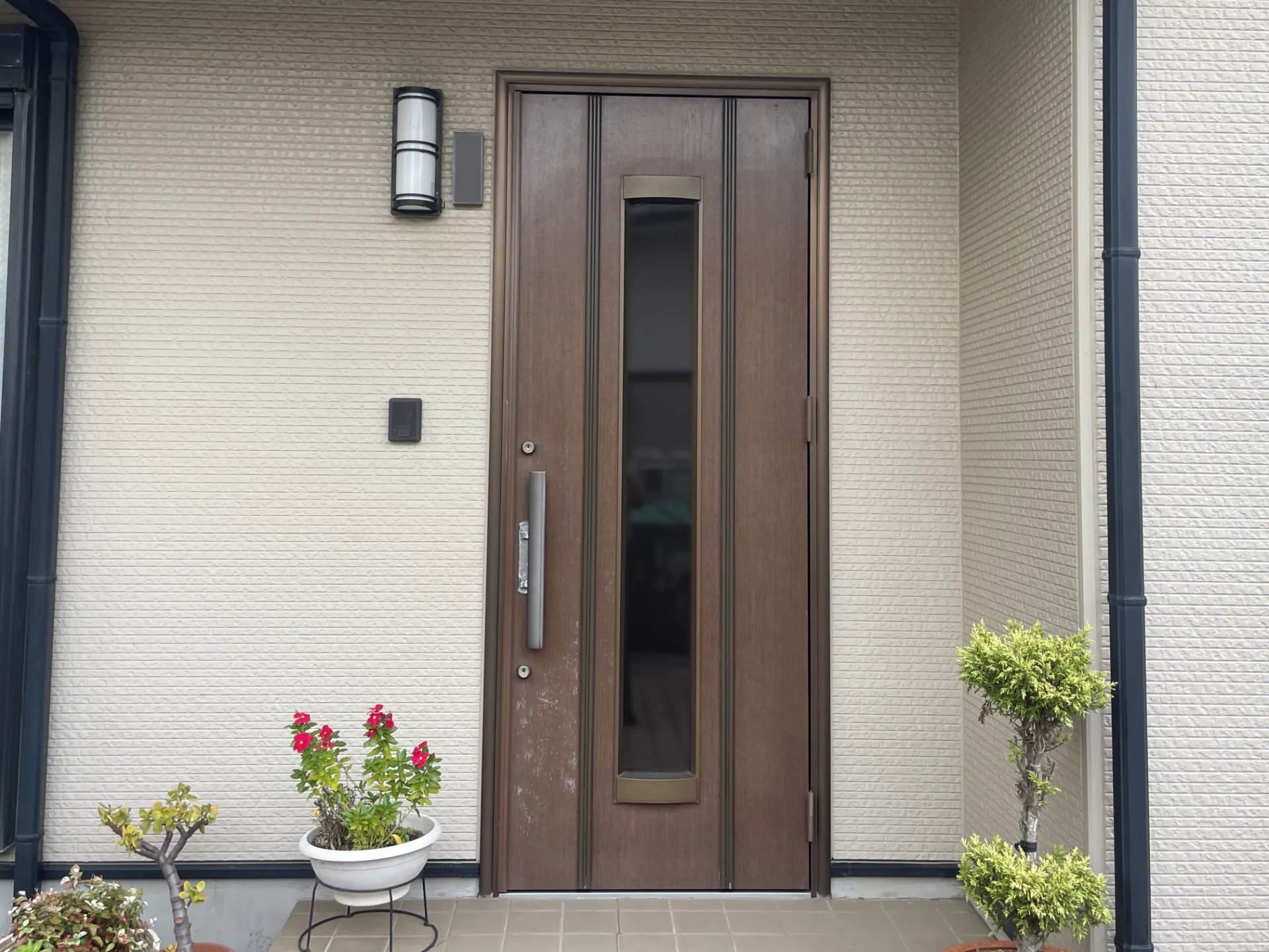 玄関ドア施工前。表面に擦れが見られる既存ドア